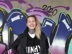 Tattooschnalle aus Deutschland vor der Graffiti Mauer genagelt